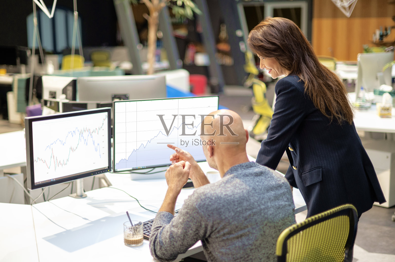 一群商务人士围坐在办公室里，围着电脑一起工作照片摄影图片