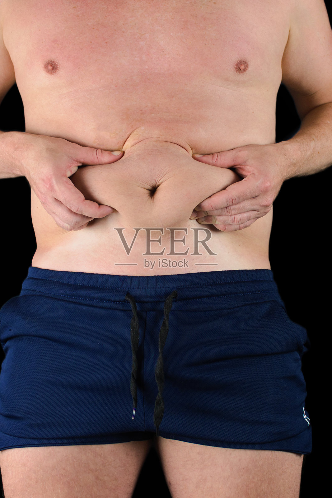 光膀子的男人抓腹部脂肪照片摄影图片