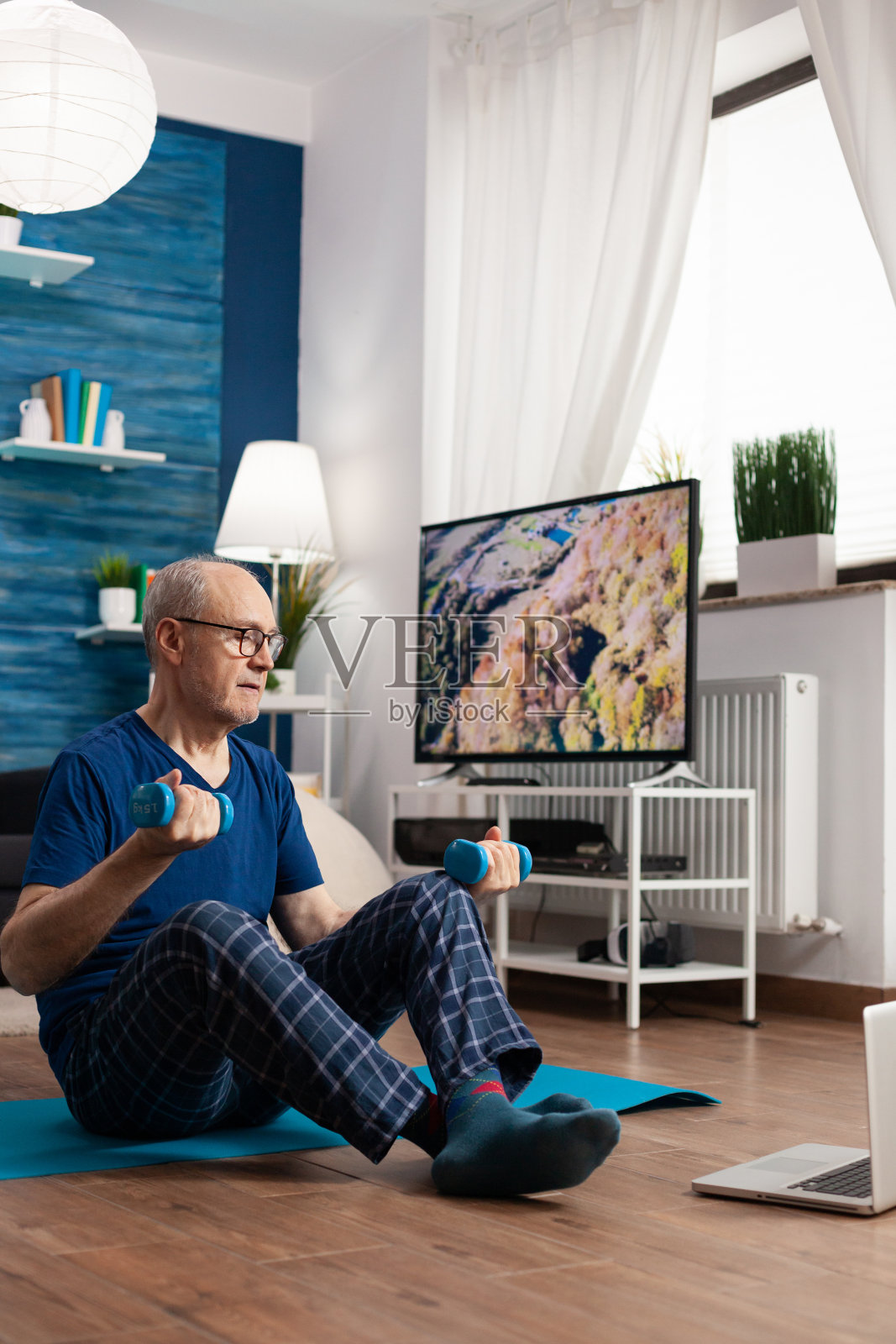 退休老人坐在瑜伽垫上伸展腹部肌肉照片摄影图片