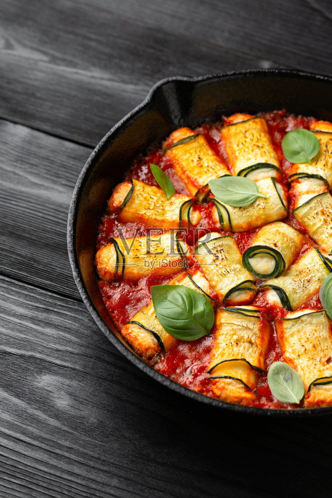 烤西葫芦卷配意大利乳清干酪，羊奶干酪和意大利番茄酱。健康的食物照片摄影图片