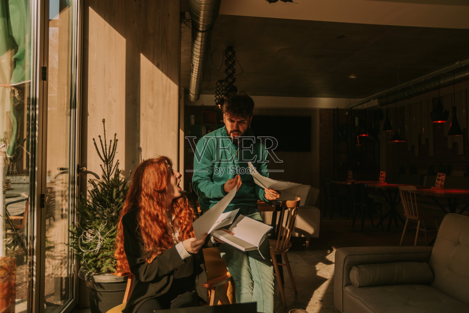 英俊的商人和他的红发女商人争吵。她在大喊大叫照片摄影图片