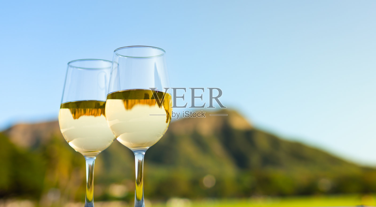 一对葡萄酒杯在美丽的热带背景下。照片摄影图片