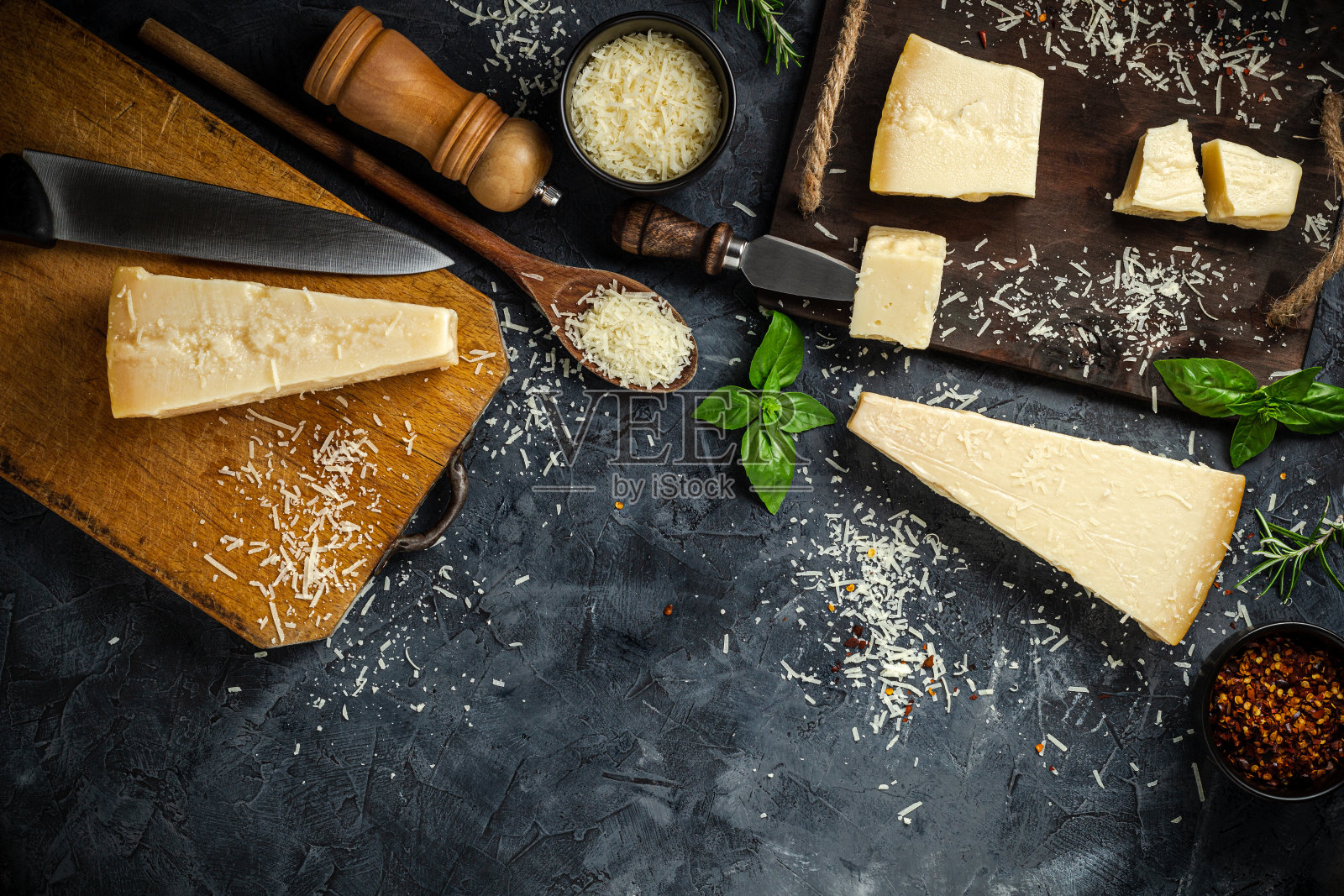 一套硬奶酪与奶酪刀在黑色石头的背景。帕尔玛。前视图。为你的文字腾出空间。照片摄影图片