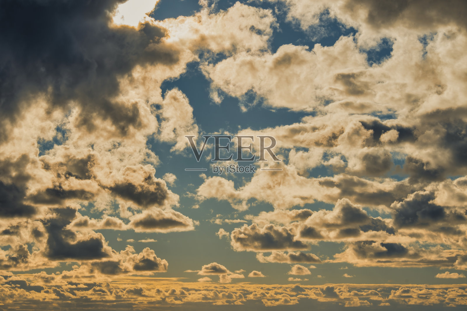 日落时的天空。被太阳的黄橙色照亮的云。照片摄影图片