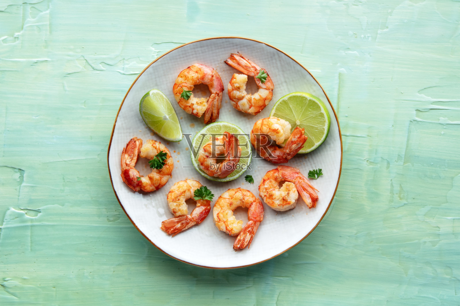 对虾，头顶平击球。白盘子里的熟虾配酸橙照片摄影图片