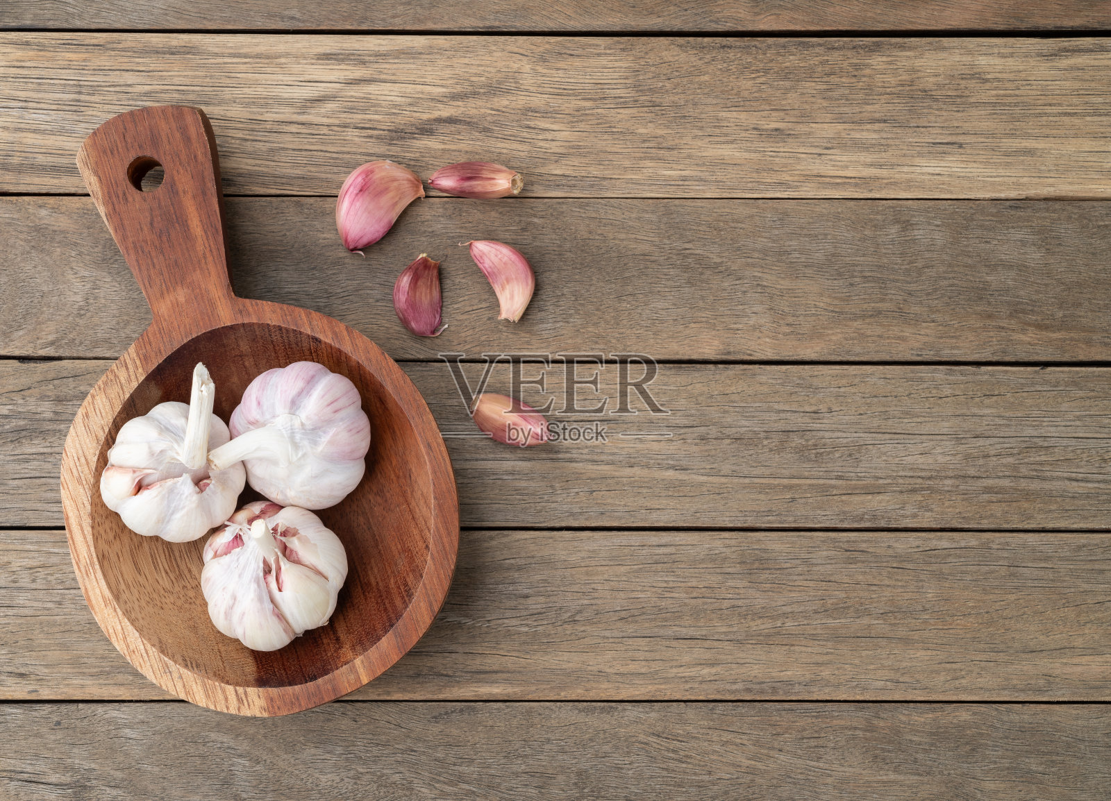 蒜头和蒜瓣放在木桌的盘子上，有复制空间照片摄影图片