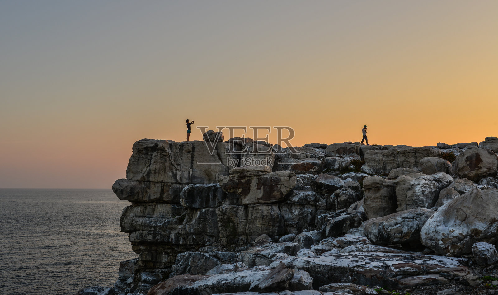 旅行者站在岩石上照片摄影图片