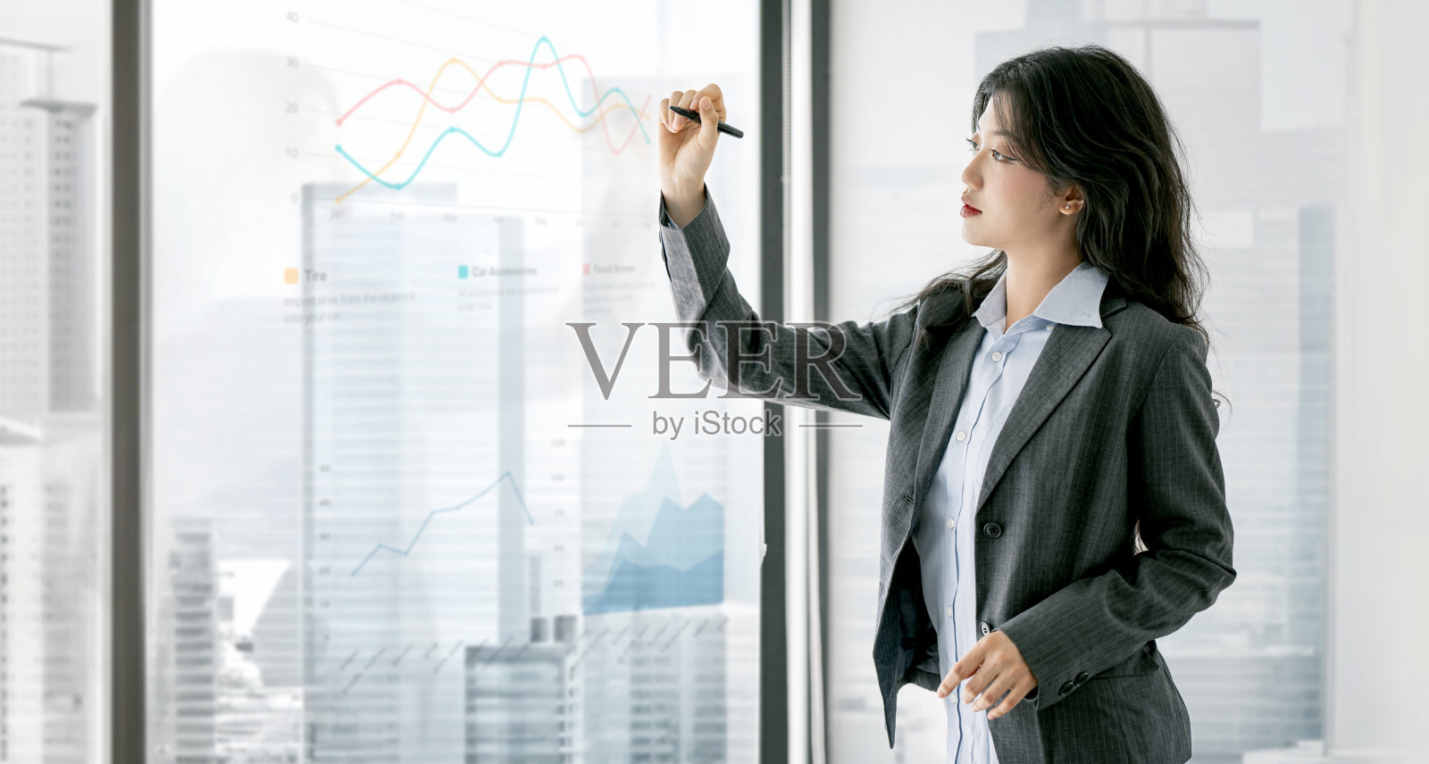 年轻的行政经理女商人在办公室里做商业项目演示，在玻璃墙上写战略想法照片摄影图片