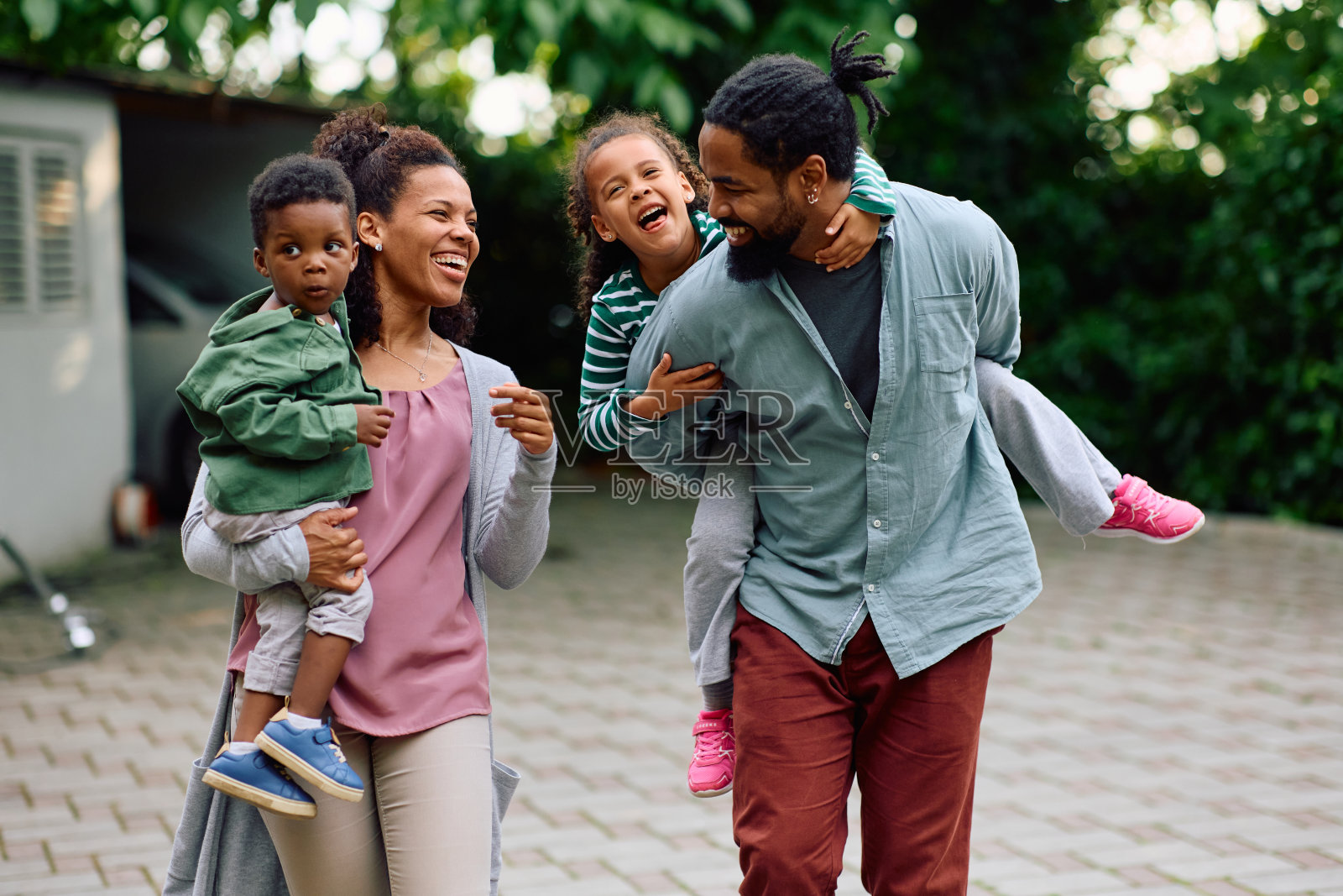快乐的黑人父母带着孩子在户外享受家庭日。照片摄影图片
