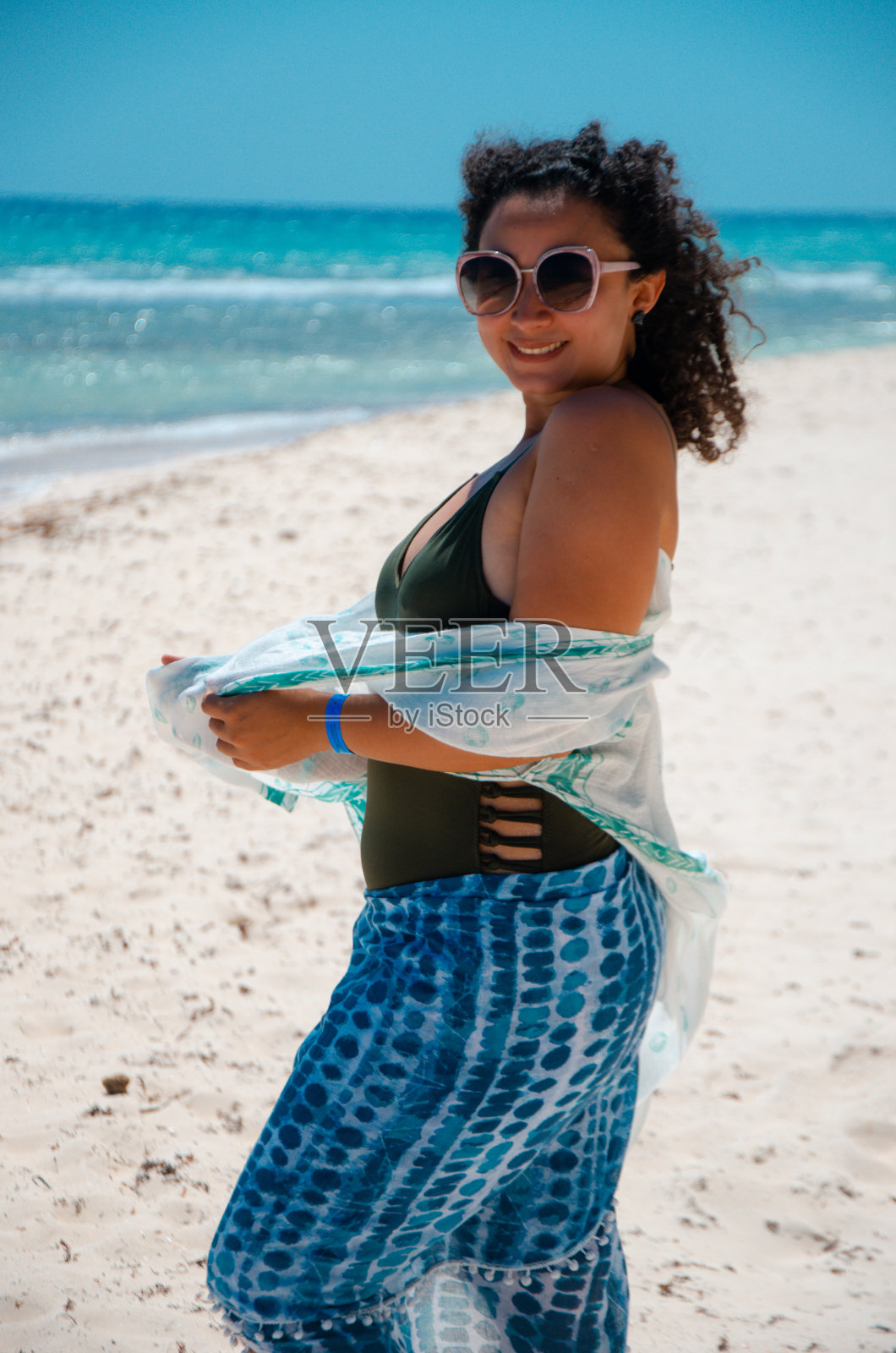 度假的年轻女子在海滩上散步照片摄影图片