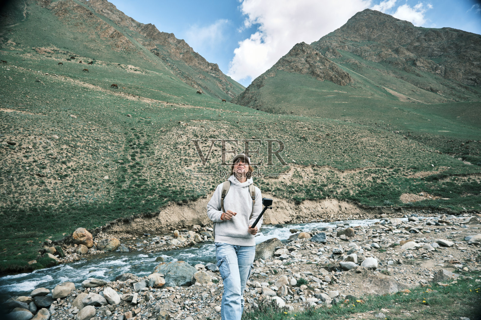 一位背包客正在拍摄她在山河上的旅行视频照片摄影图片