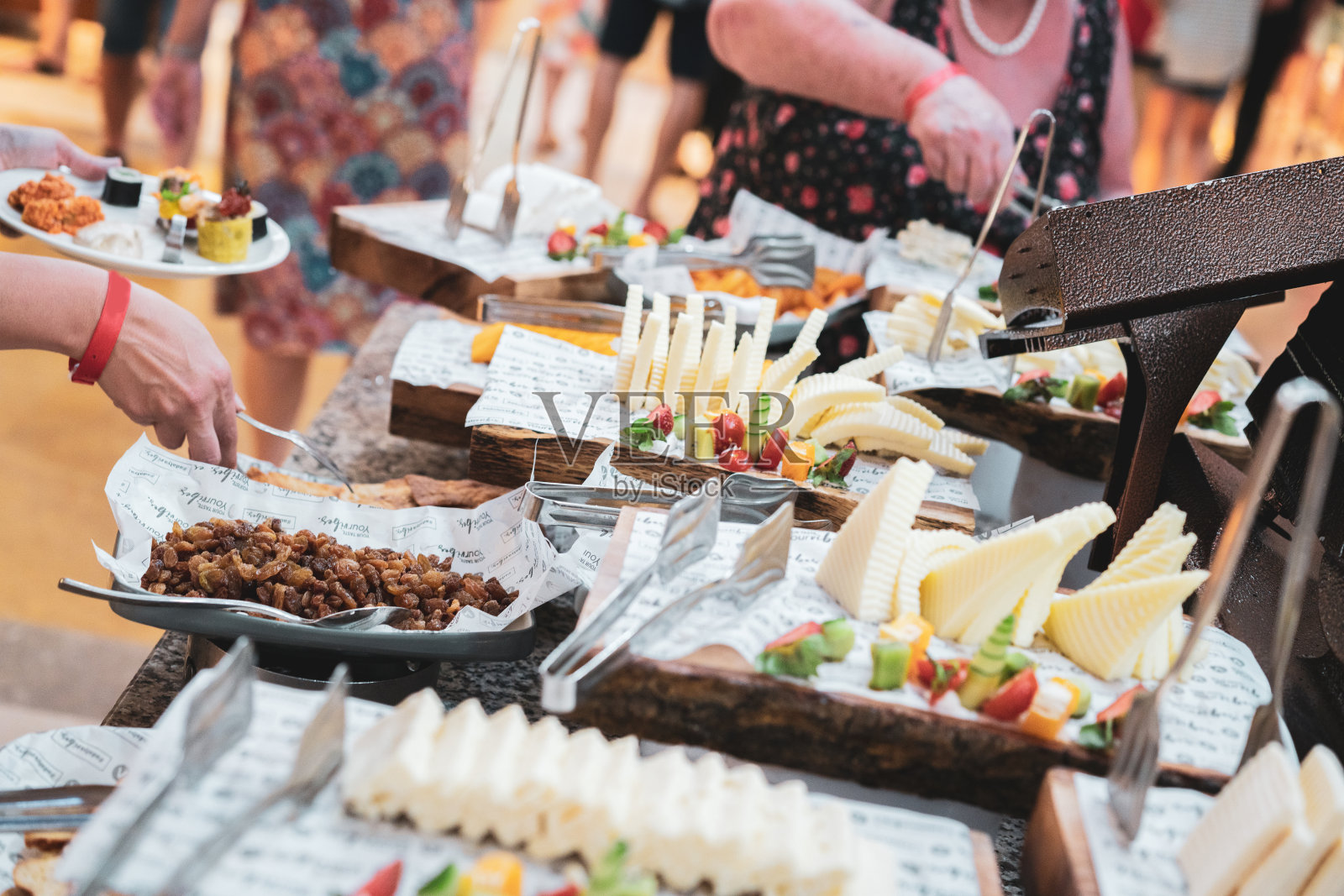 人们的盘子里装着不同的奶酪。照片摄影图片