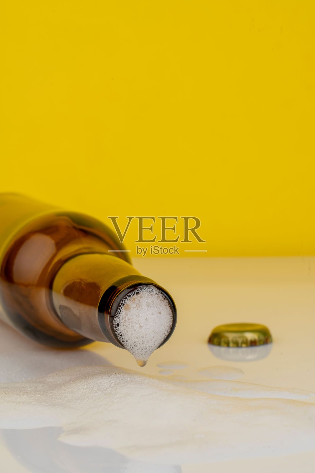 一个啤酒瓶的孤立的镜头，它的盖子打开，饮料在表面流动照片摄影图片