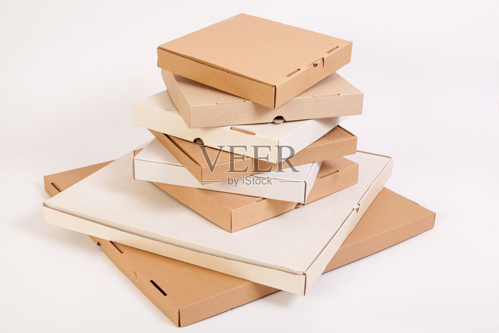 不同大小和颜色的披萨盒。一堆高高的披萨盒照片摄影图片