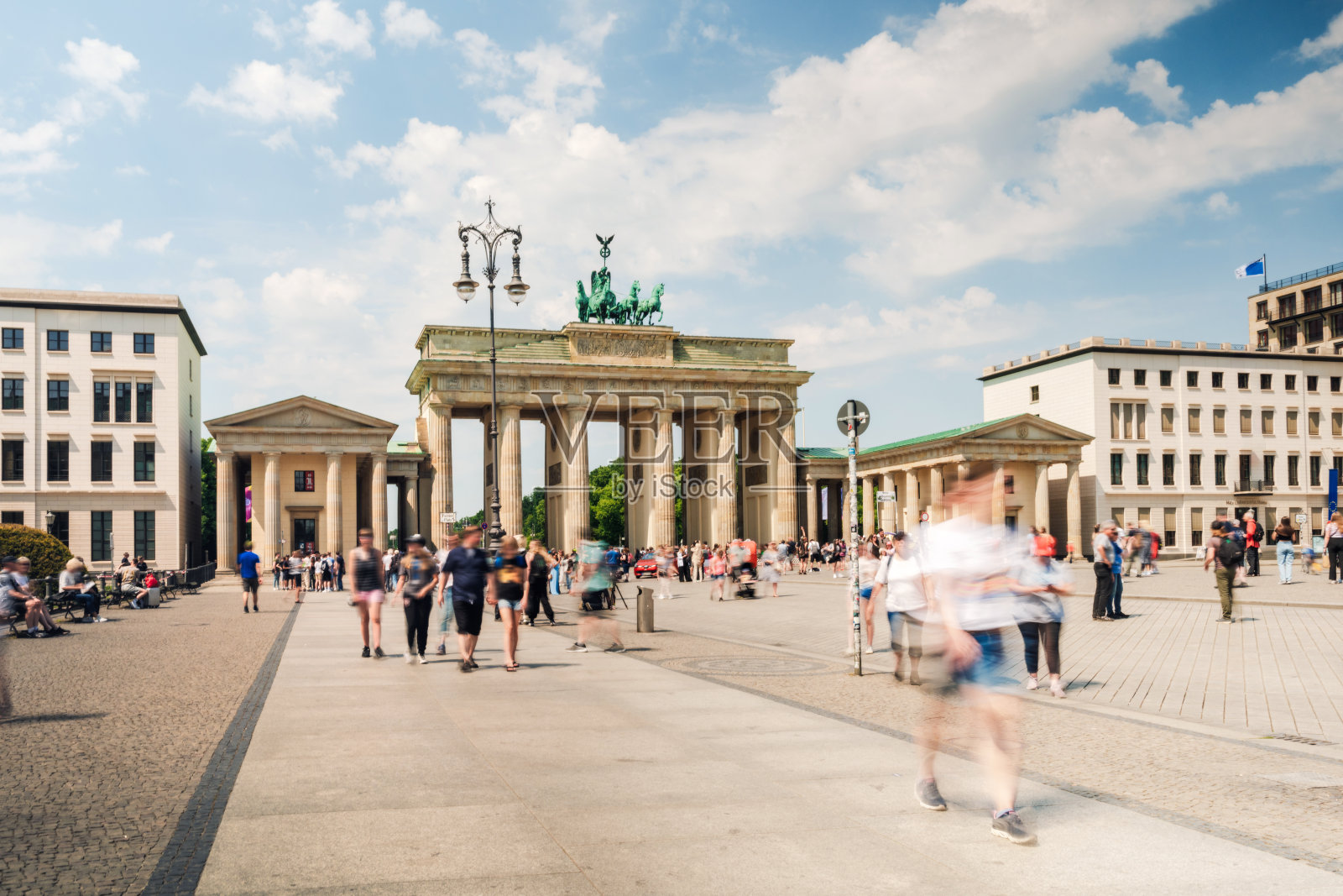 阳光明媚的日子里，游客们聚集在柏林勃兰登堡门前照片摄影图片