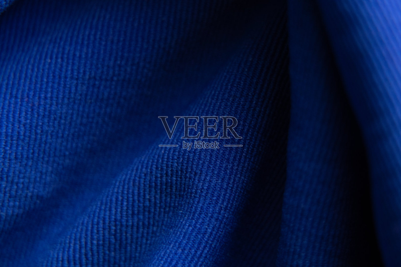 深蓝色波浪织物作为背景特写照片摄影图片