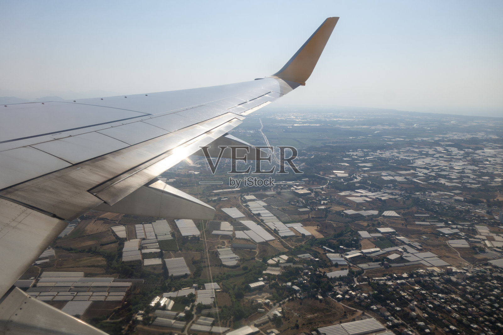 飞机的机翼在天空的云层上飞行照片摄影图片