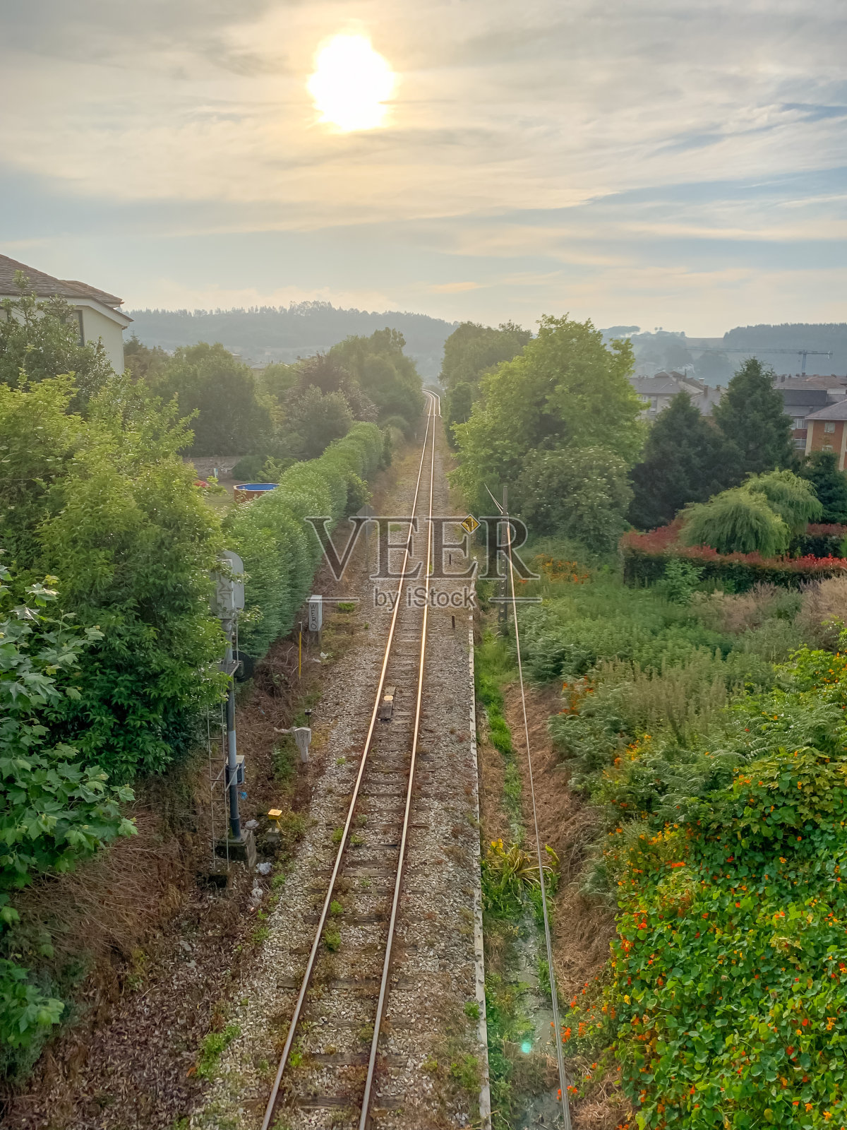 夕阳下的铁轨。铁路线映衬着色彩斑斓的蓝天，出行理念背景。铁路旅行，铁路旅游。运输火车轨道。垂直拍摄照片摄影图片