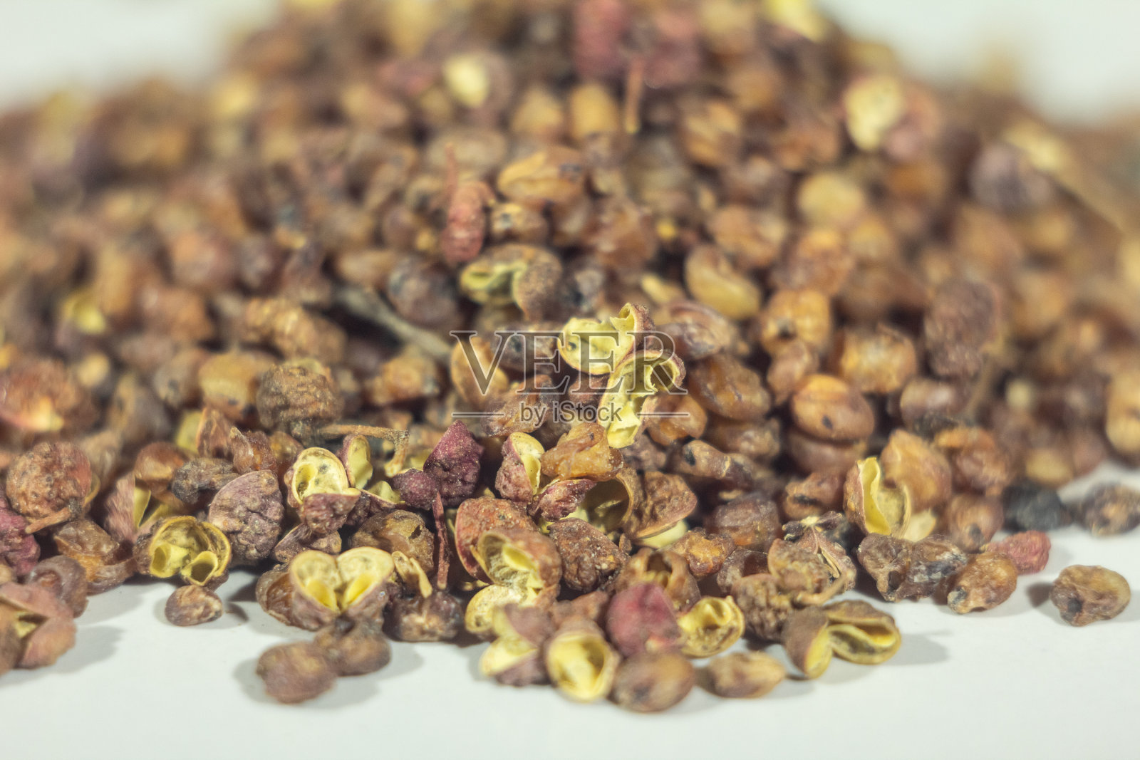 在白色背景上选择模糊一堆和一堆花椒。这是一种中国香料，叫花椒，花椒，花椒，花椒，麻椒照片摄影图片