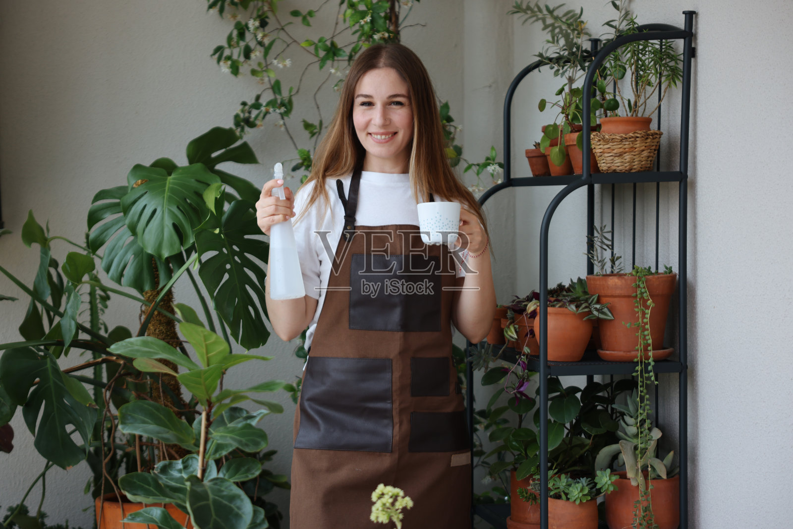 可爱的家庭主妇，花盆里有花，还有园艺套装照片摄影图片