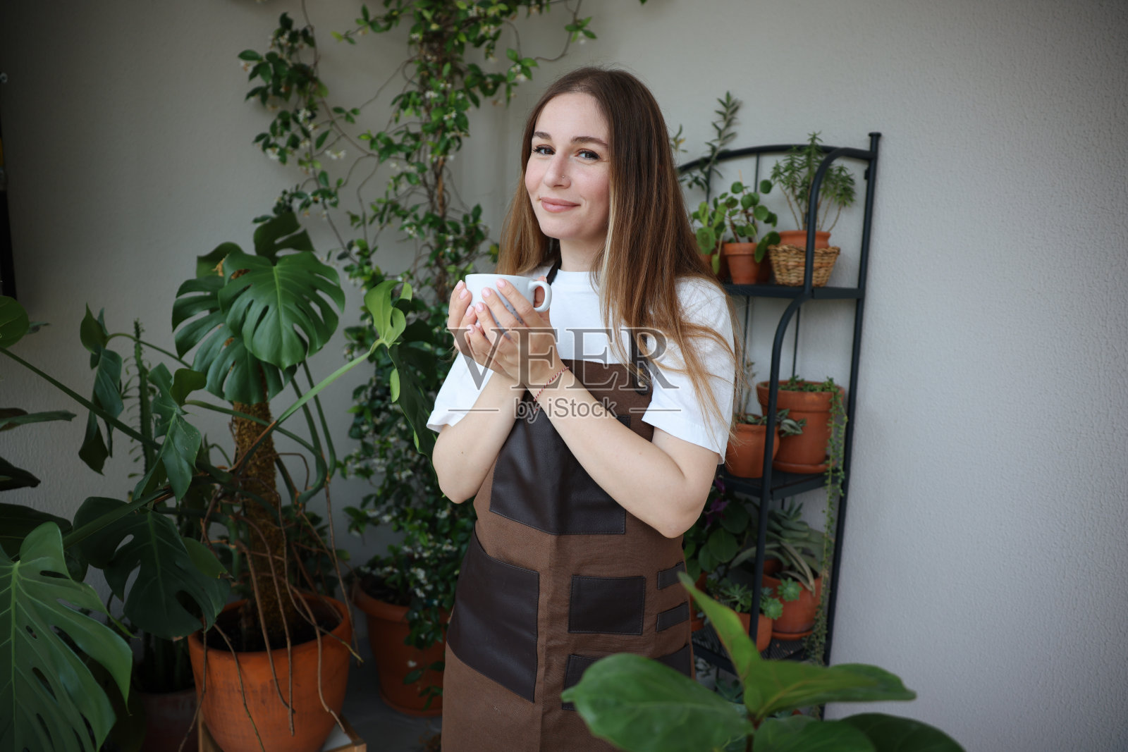 可爱的家庭主妇，花盆里有花，还有园艺套装照片摄影图片