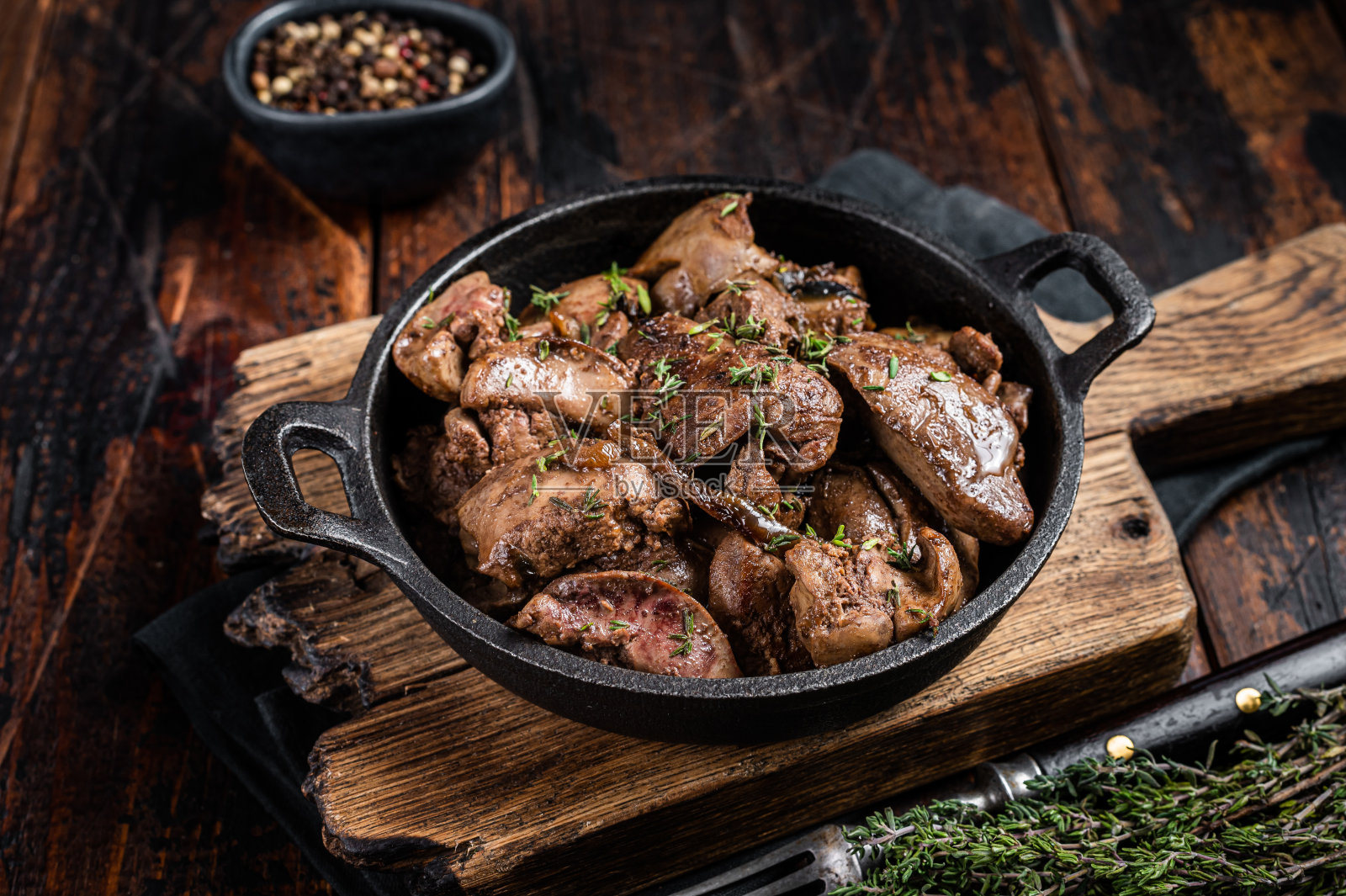 用煎锅煎洋葱烤鸡肝。木制背景。俯视图照片摄影图片