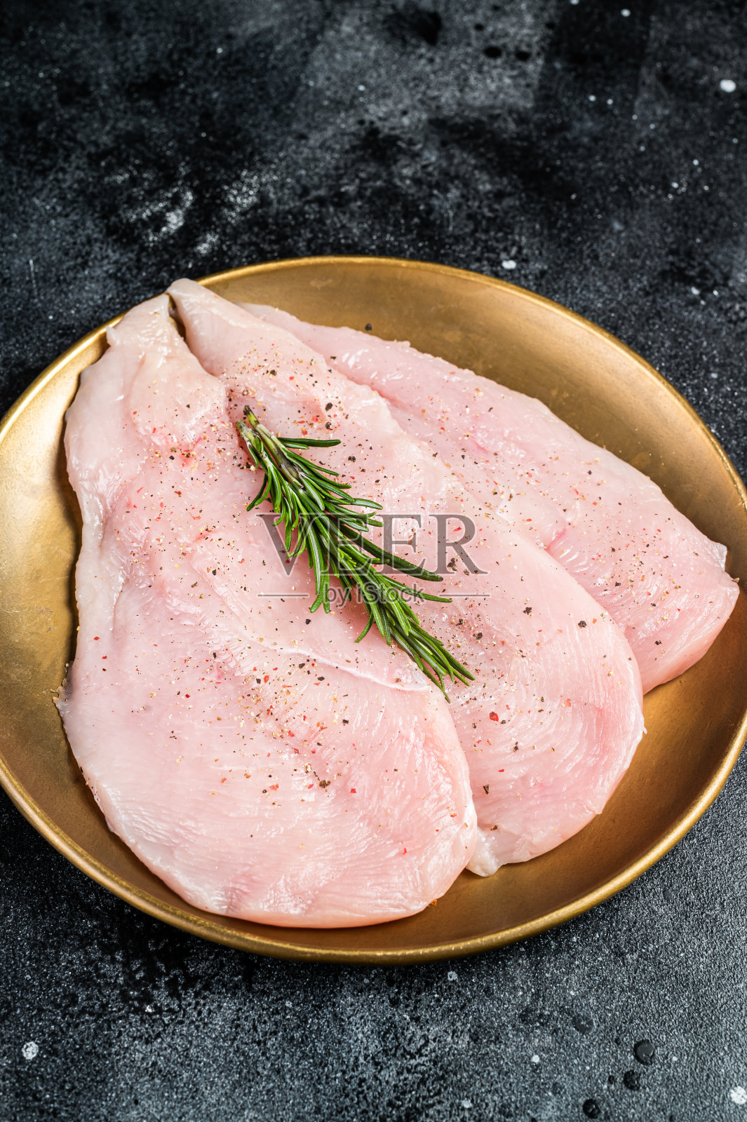 生鸡块，胸脯片，禽肉。黑色背景。俯视图照片摄影图片