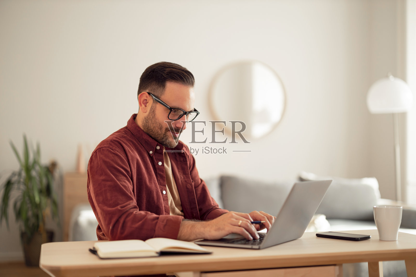 一个专注的人在笔记本电脑上打字，在家上网工作。照片摄影图片