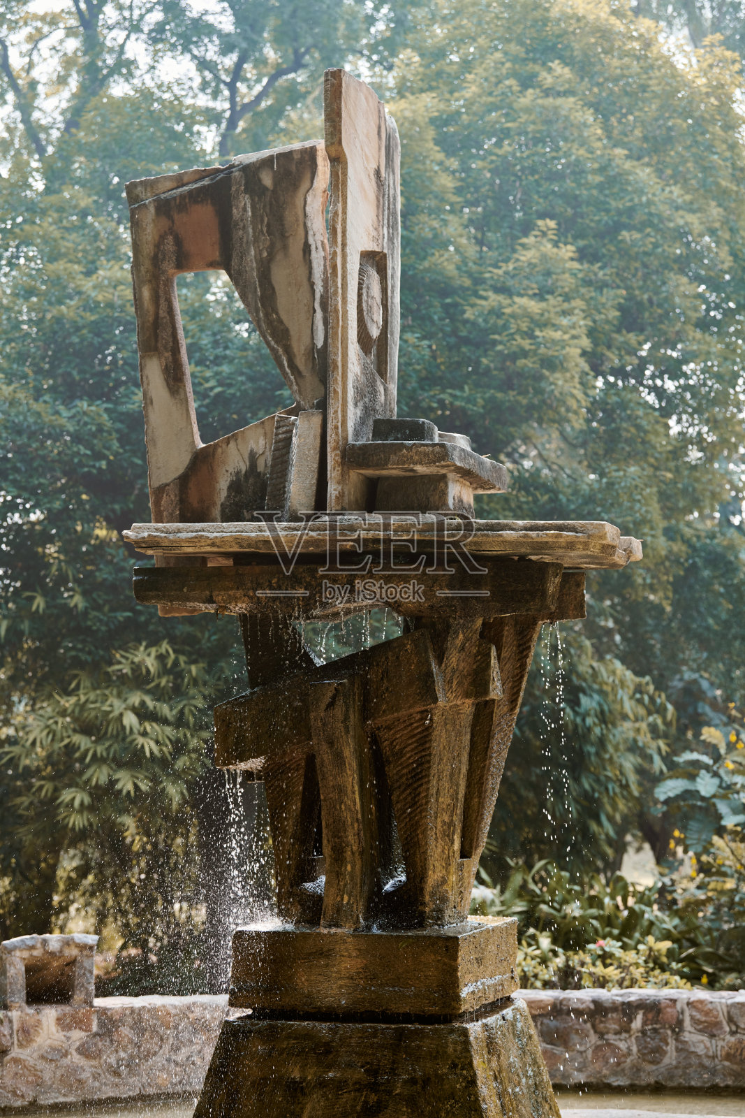 城市公园绿植间的装饰性喷泉，抽象的建筑结构照片摄影图片