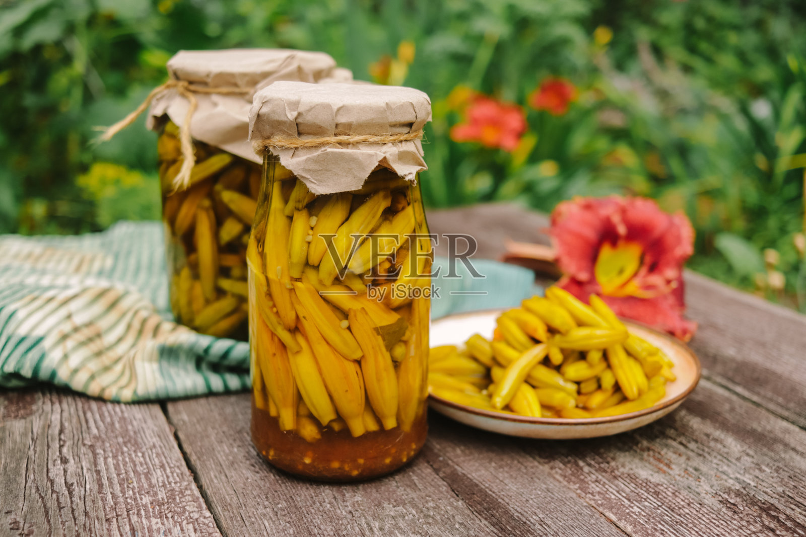 在木制表面的玻璃罐里泡过的黄花菜照片摄影图片