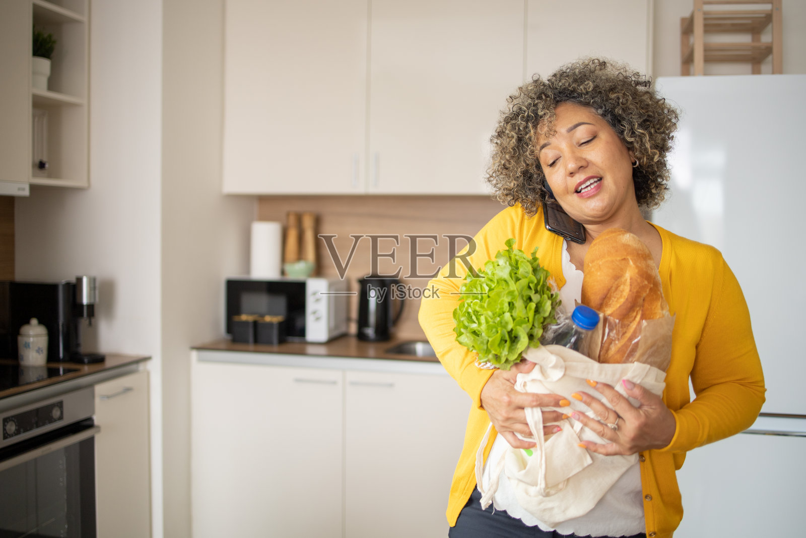 一个成熟的女人正从杂货店买东西回来照片摄影图片
