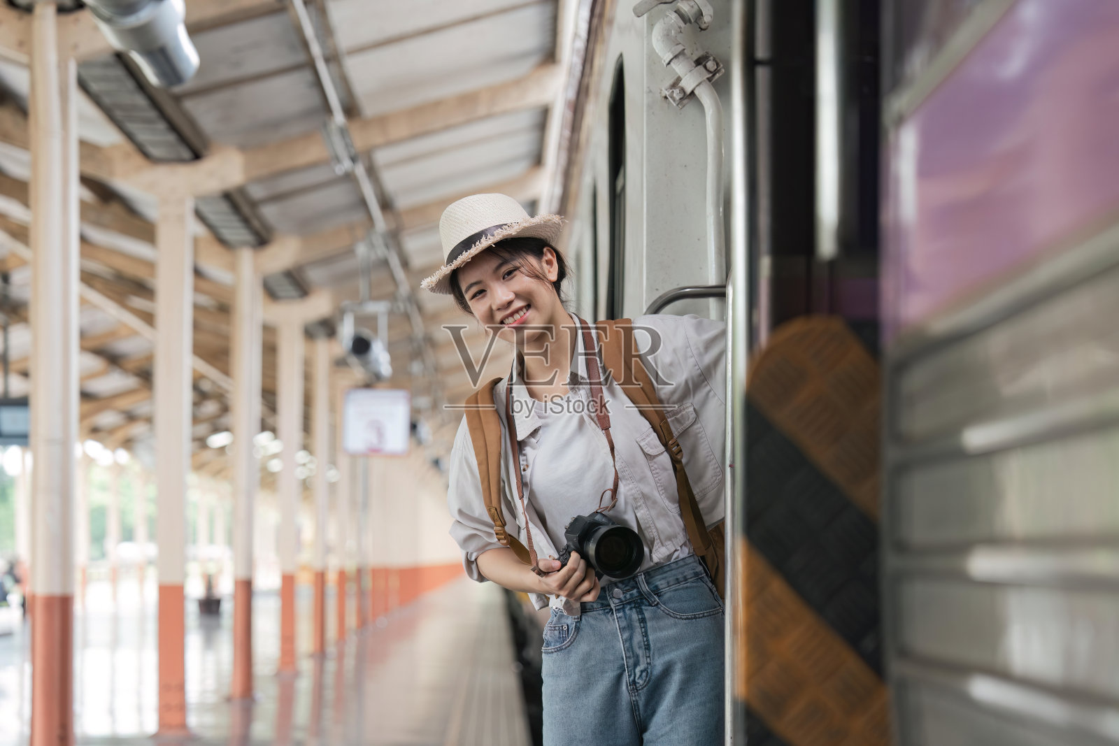 肖像吸引亚洲女子在火车站登上火车旅行。旅游的概念照片摄影图片
