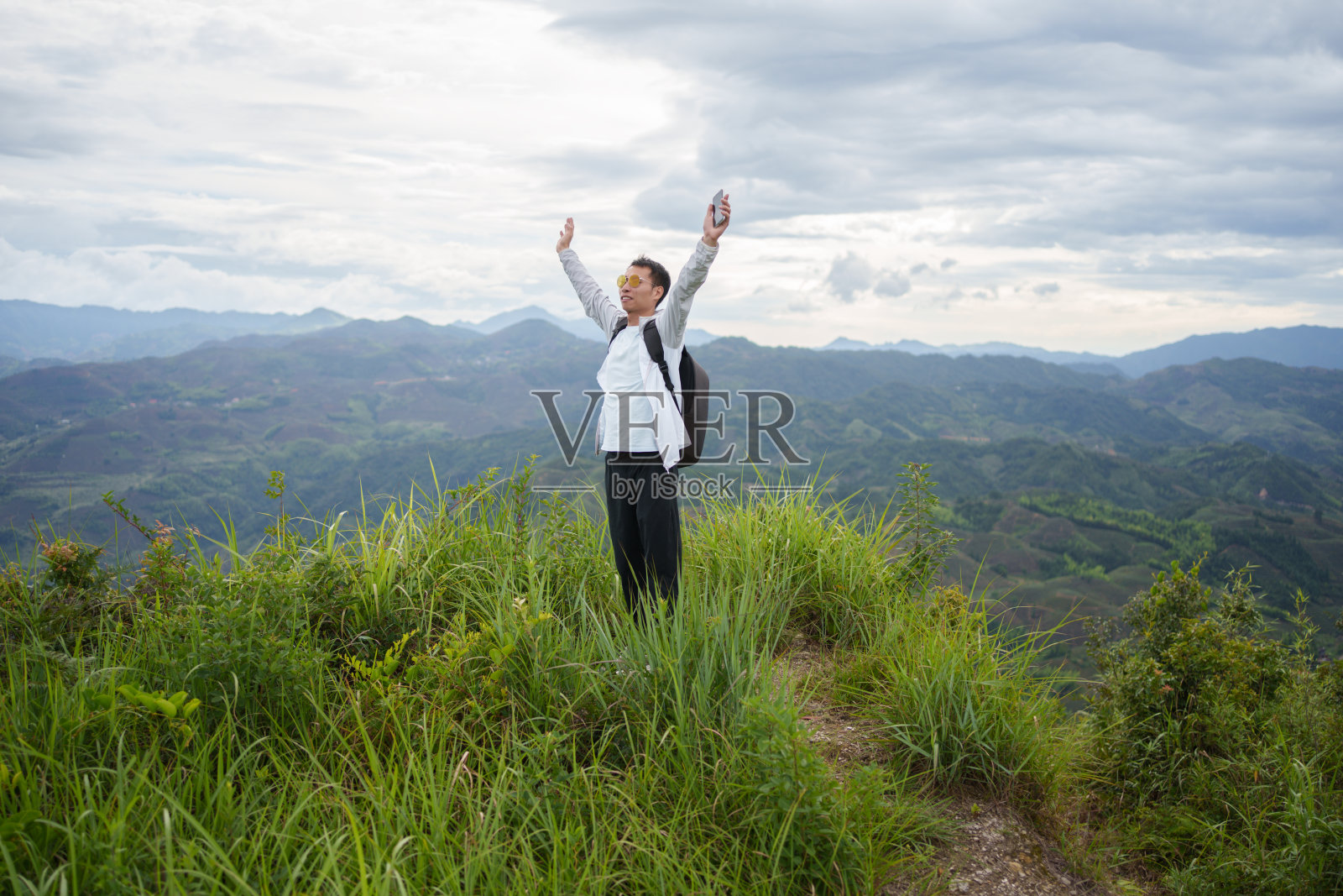 一个人庆祝到达山顶照片摄影图片