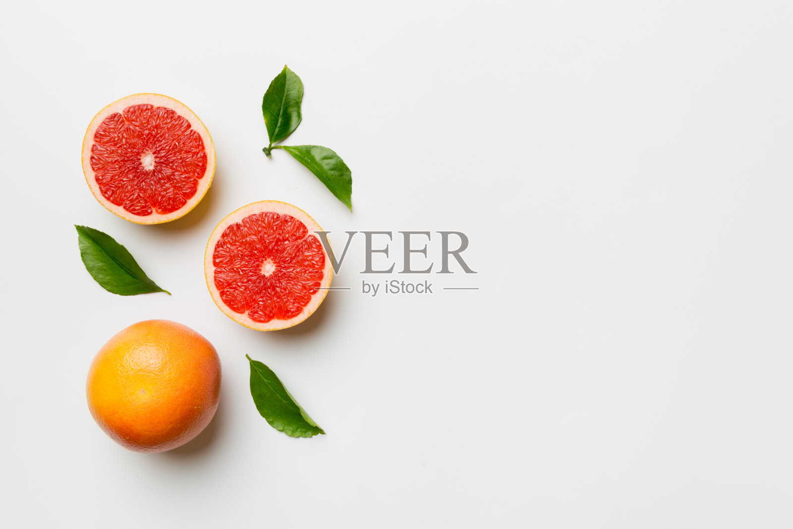 新鲜的柚子和多汁的柚子切片在彩色背景上。前视图。副本的空间。创造性的夏天的概念。一半的柑橘在最小的平面与复制空间照片摄影图片