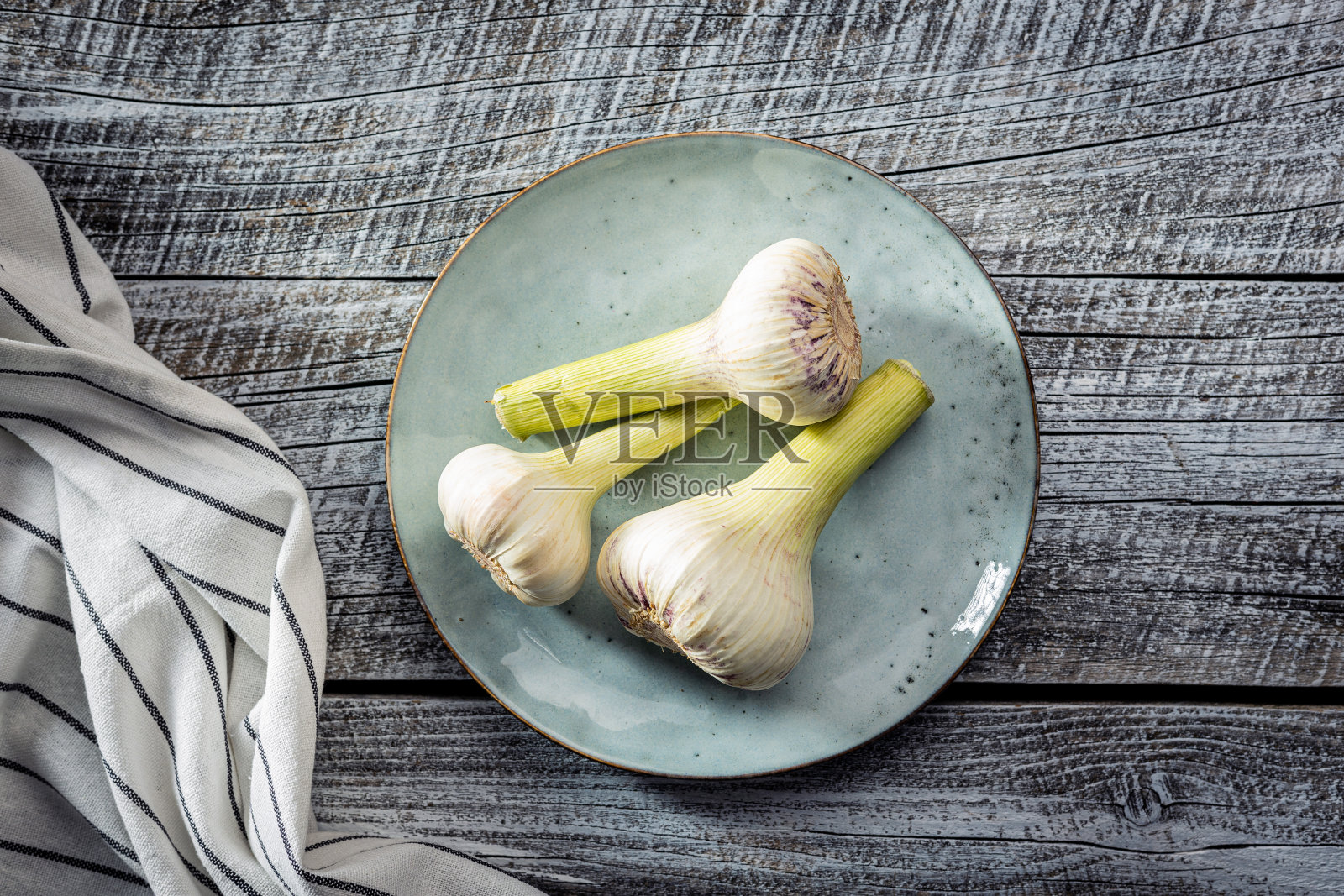 整个蒜头。新鲜的白蒜放在木桌上。照片摄影图片