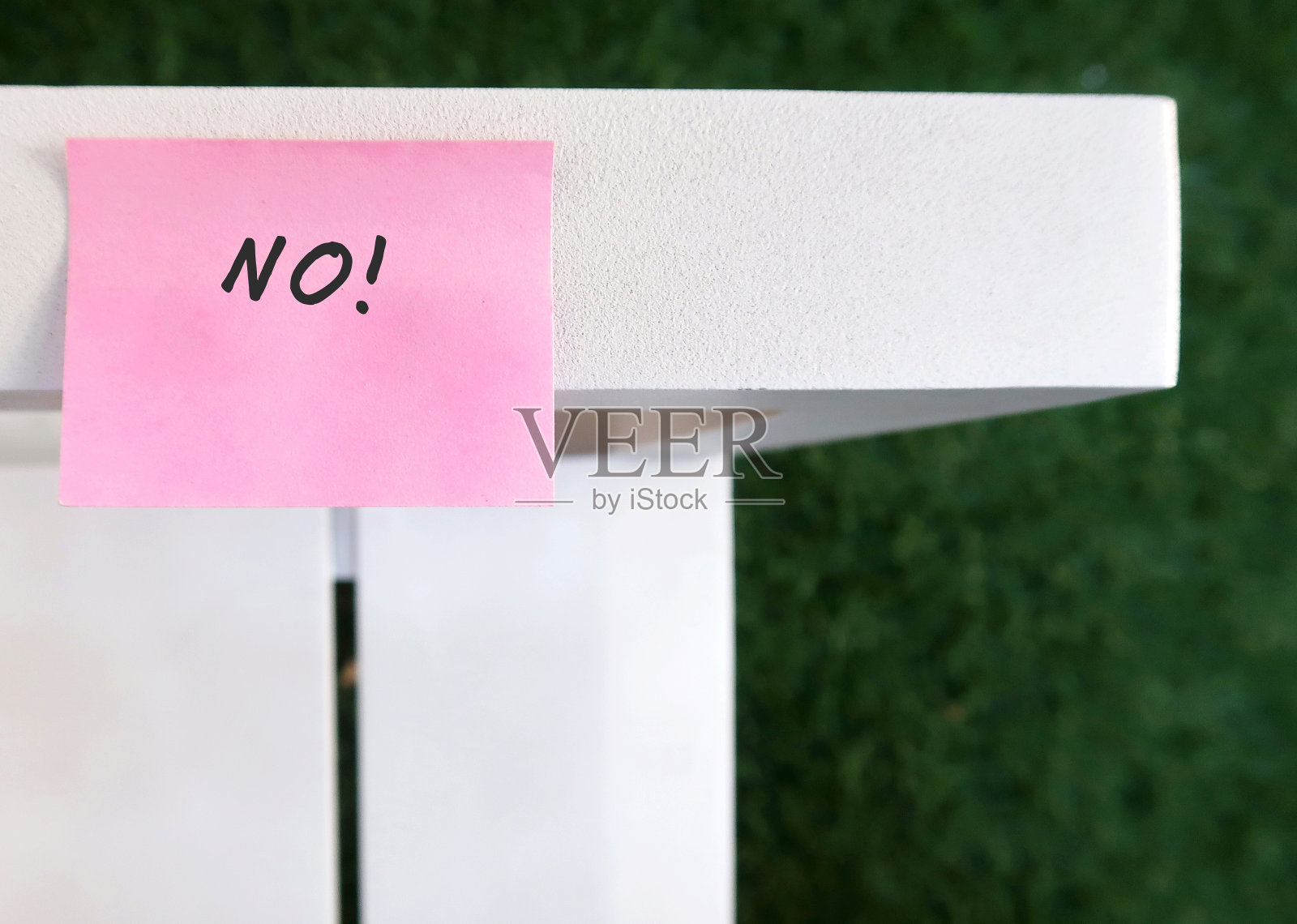 手写短信NO!粉红色的音符贴在白色的长凳上，代表校长的概念，勇于说不，停止讨好别人照片摄影图片