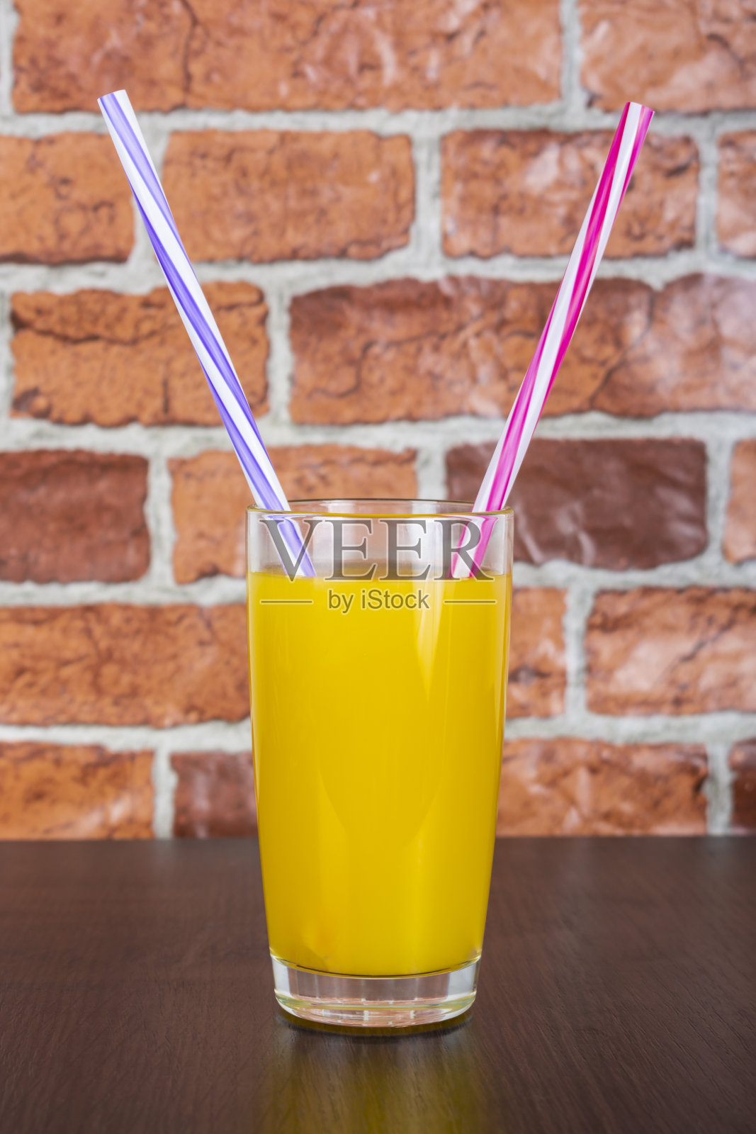 橙汁两根吸管维他命健康理念木质背景和砖墙照片摄影图片