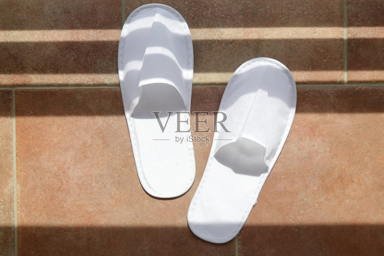 白色的酒店拖鞋。毛巾一次性水疗客人鞋。俯视图照片摄影图片