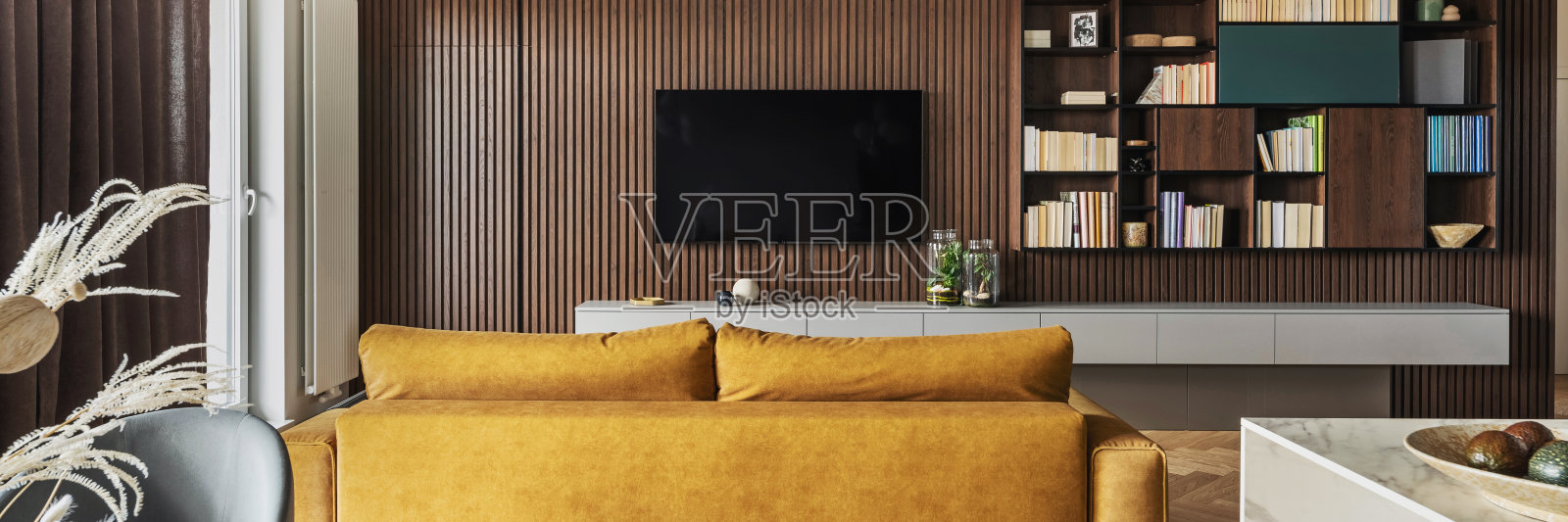 创意和现代复古客厅室内设计与黄色沙发和薄板墙与电视和书柜。人字镶木地板，五斗橱，棕色窗帘。模板。照片摄影图片