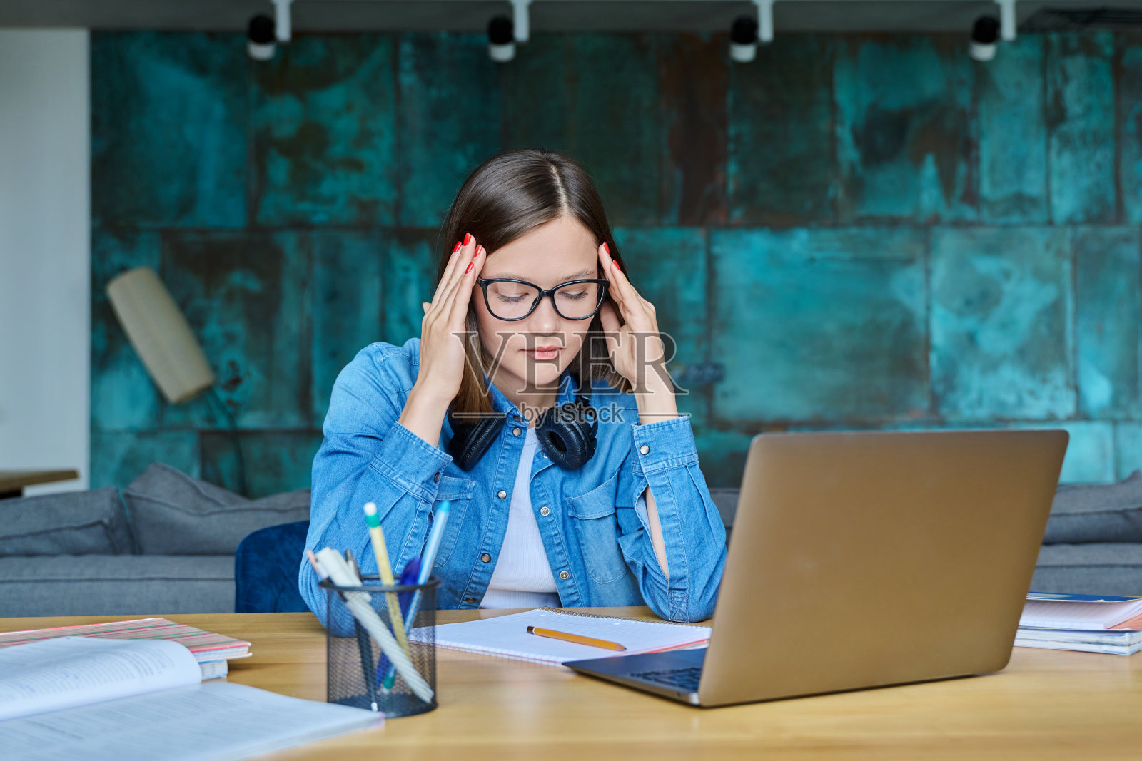 在书桌前的不快乐的悲伤的女大学生照片摄影图片