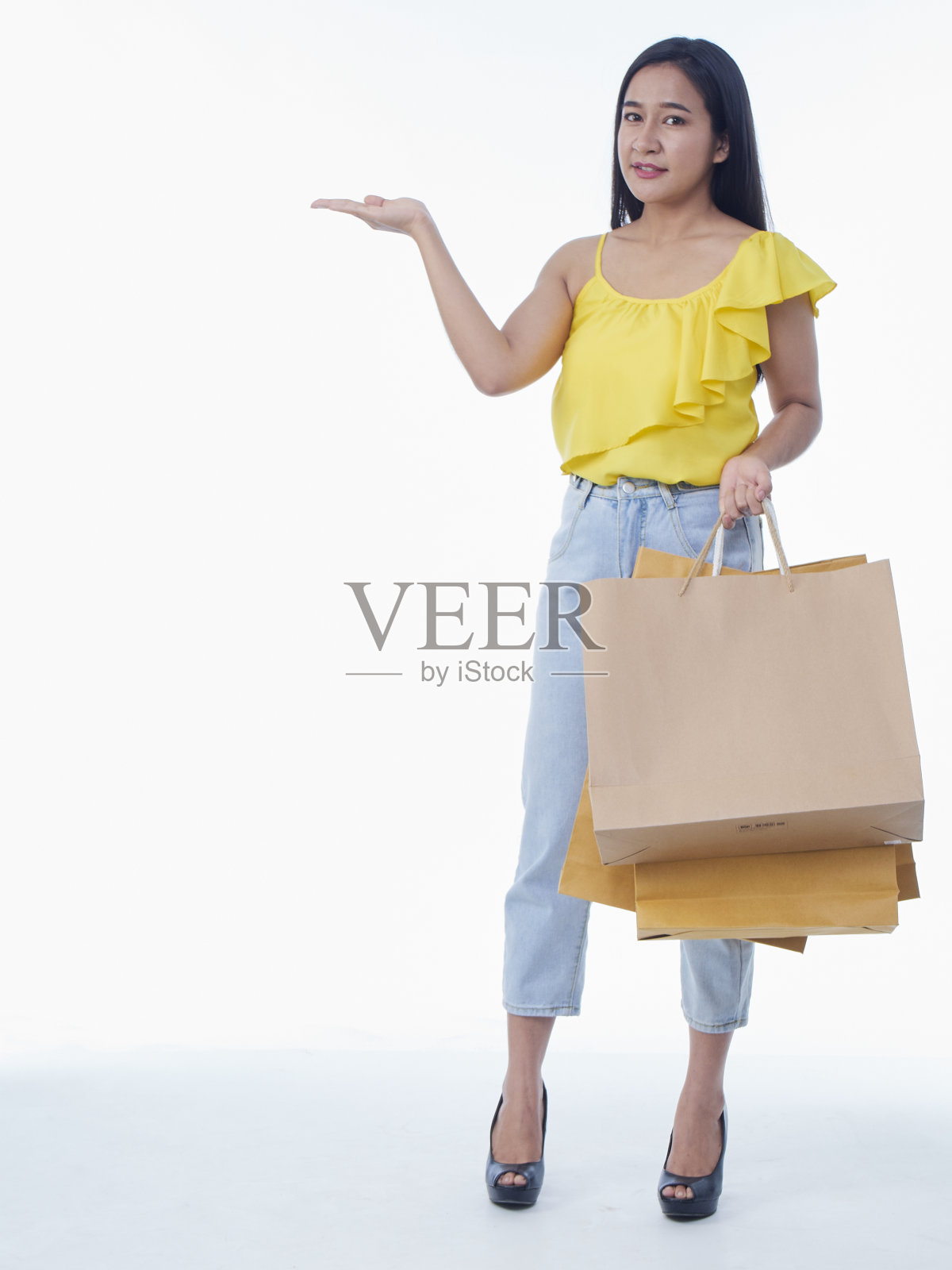 漂亮的年轻女子拿着白色背景的购物袋照片摄影图片