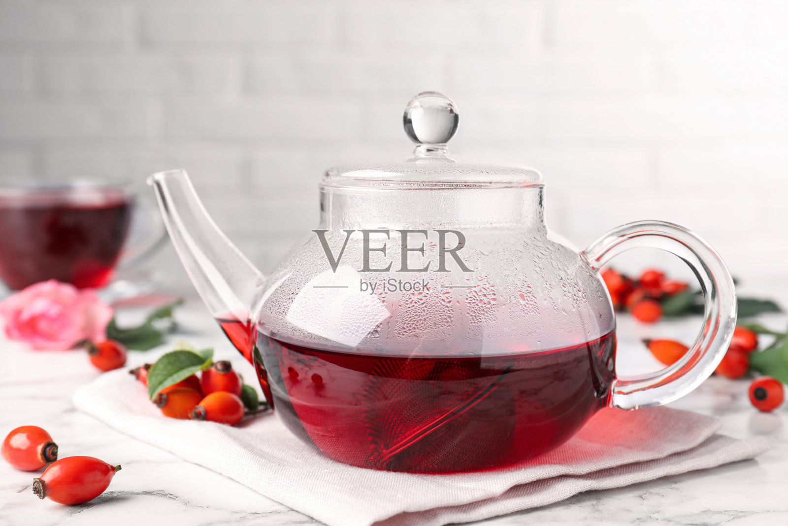 新鲜的玫瑰茶和浆果在白色大理石桌子上照片摄影图片