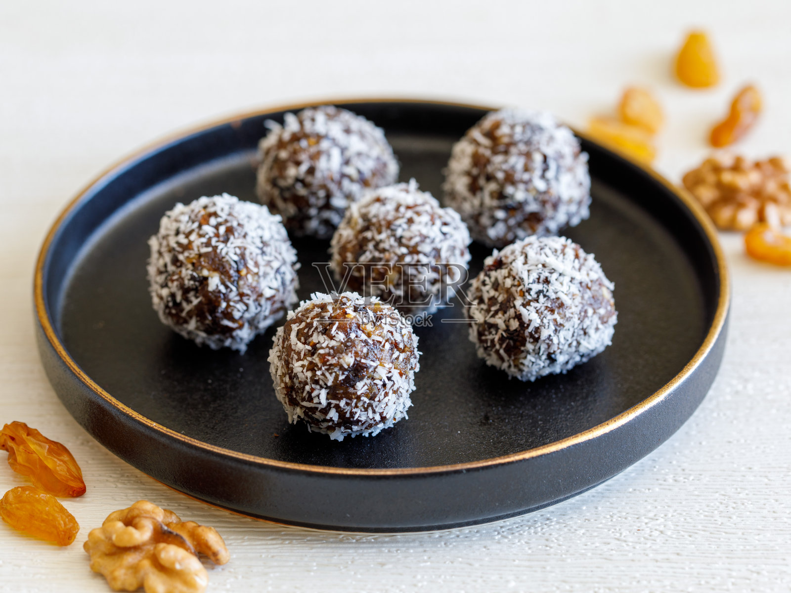 健康自制美味的能量球:用葡萄干，西梅，枣，核桃，无花果做成的黑色盘子的球甜点蛋糕照片摄影图片