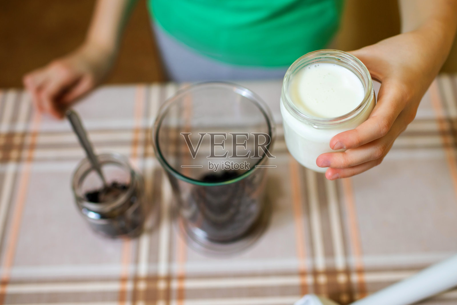 女孩喝着紫黑醋栗，酸奶和奇亚籽制成的冰沙照片摄影图片