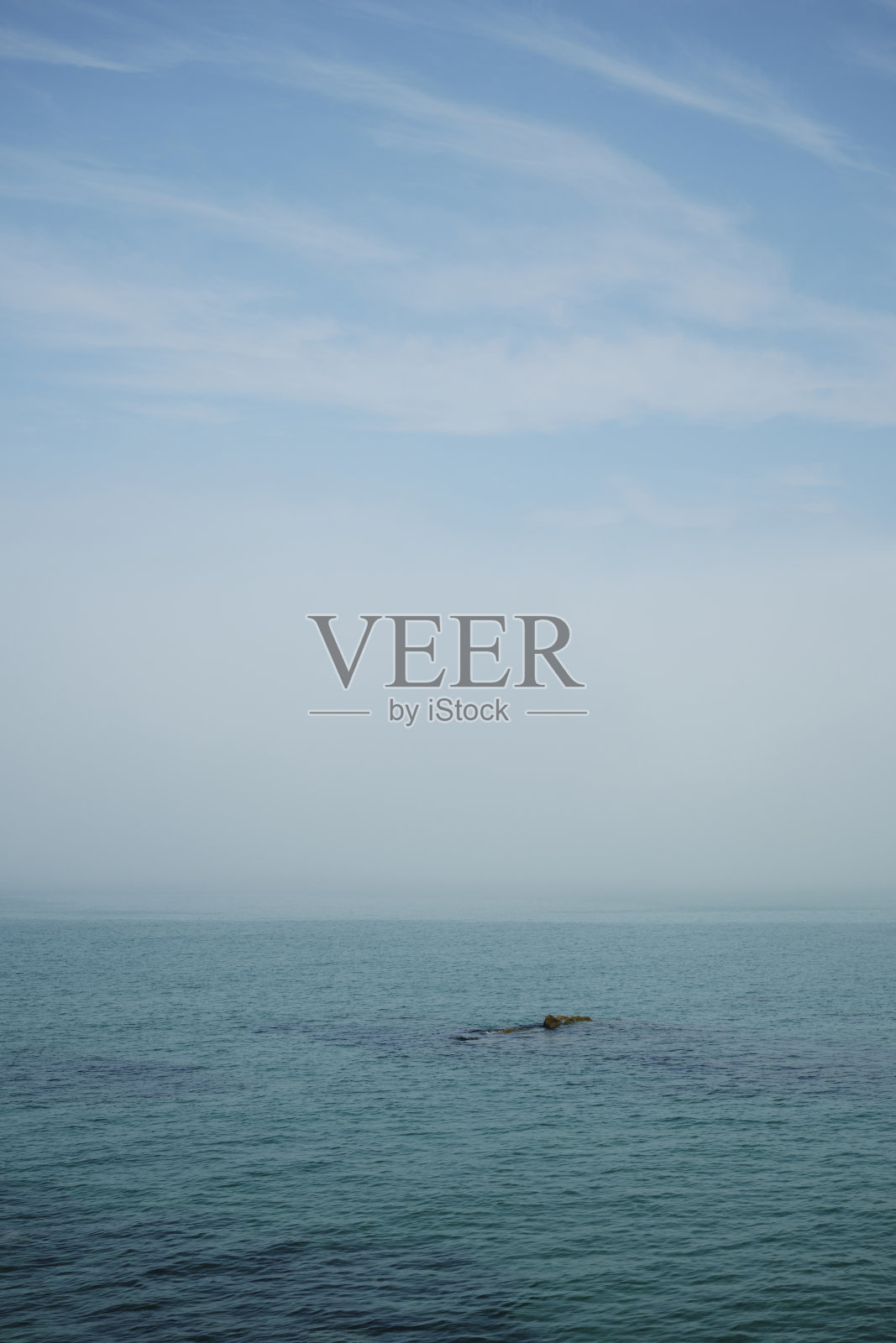 六月的一天，康沃尔郡纽基湾，蔚蓝的大海和天空，中间有挥之不去的海雾。照片摄影图片