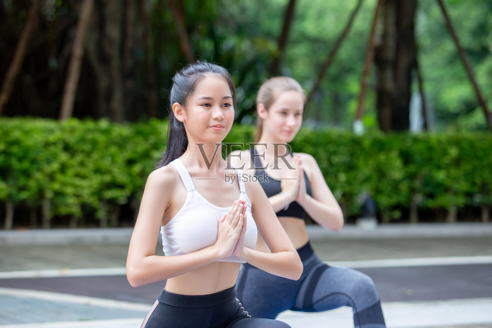 放松瑜伽的运动概念。健康的休闲。穿着运动服的女子做瑜伽锻炼。女性静坐瑜伽祈祷姿势瑜伽在室外地板上。照片摄影图片