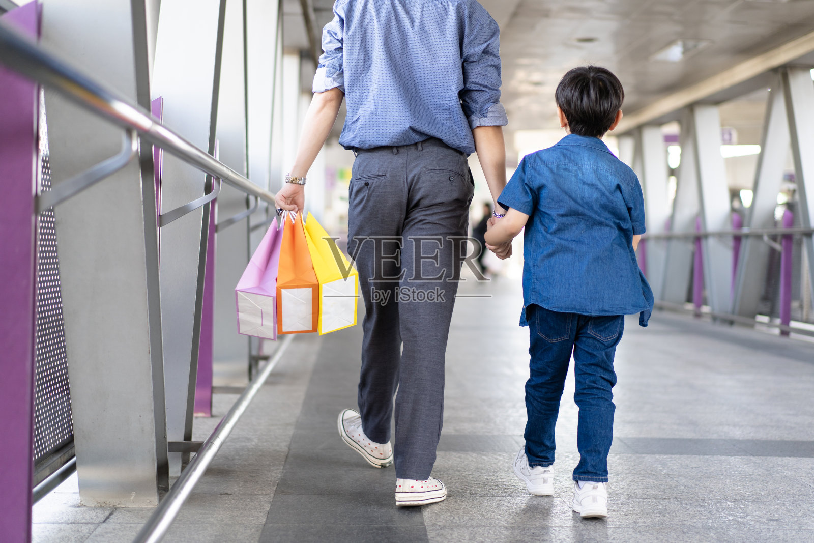男人和儿子一起在城市里旅行。照片摄影图片