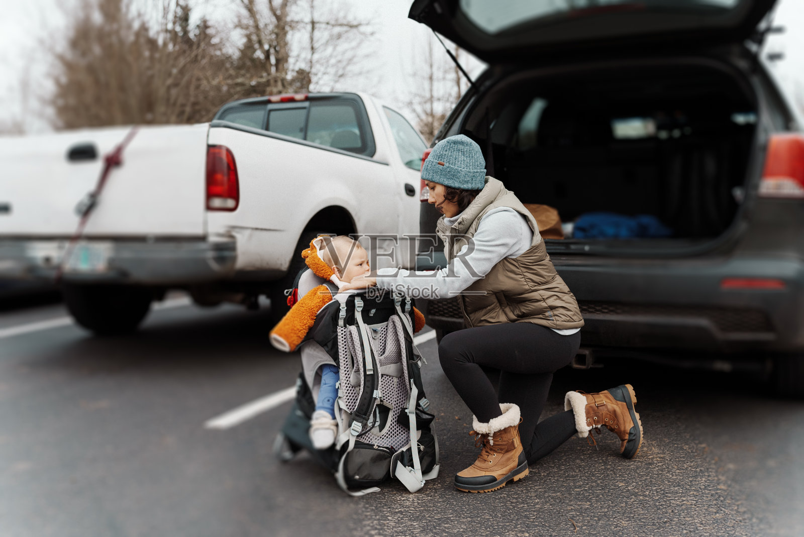 母亲把婴儿捆在背带里照片摄影图片