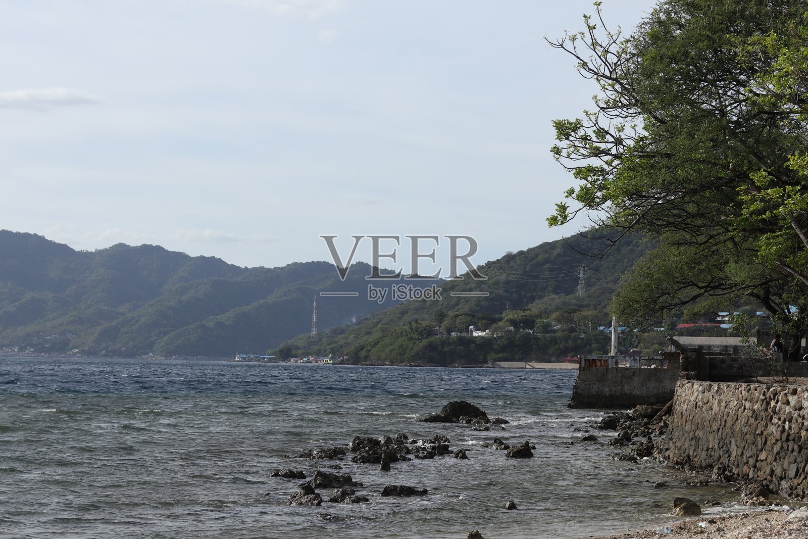 傍晚海边的景色，背景是山照片摄影图片