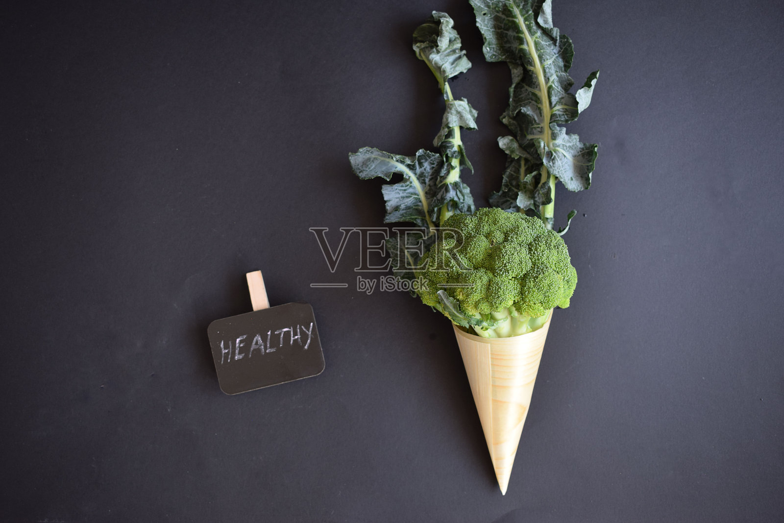 新鲜的绿色花椰菜放在一个木制的圆筒里。照片摄影图片